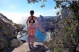Public erotica, a girl with a stunning figure shows her magnificent ass against the backdrop of the sea and mountains  DickForStepSister
